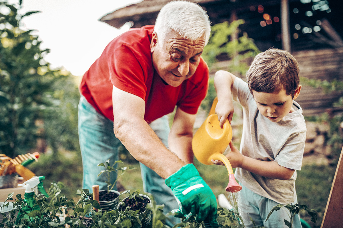 Grandfather and grandson watering the garden